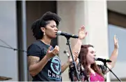  ?? Photo by Sara Vaughn ?? ■ Jessica Stewart and Lydia Smith lead the crowd in worship Saturday during Freedom Fest. The singers are with a band from Refuge Church that preformed Christian music to celebrate the Fourth of July.