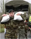  ??  ?? Soldiers from the 12th Battalion, Sarsfield Barracks, Limerick, help deliver sandbags in Clonlara, Co Clare. Photo: Liam Burke