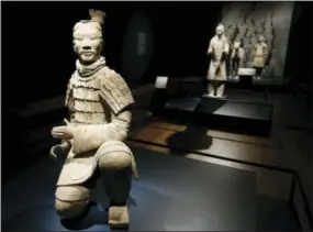  ?? STEVE HELBER — THE ASSOCIATED PRESS ?? In a Tuesday photo, visitors look over some of the Terracotta Army soldiers on exhibit at the Virginia Museum of Fine Arts in Richmond, Va. The Museum has 10 of the majestic terracotta figures on display as part of an exhibit that tells the story of...