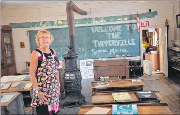  ??  ?? Janie Barkhouse in the artifact exhibit of the one-room schoolhous­e in Tuppervill­e.