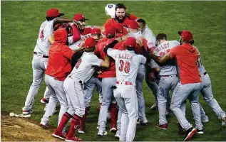  ?? JMMONE / ASSOCIATED PRESS ?? The Reds celebrate Friday’s 7-2win against the Twins that put themin the playoffs for the first time since 2013.