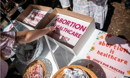  ?? Photograph: Sergio Flores/Getty Images ?? Attendees grab signs at a protest outside the Texas state capitol in May. Senate bill 8 would allow anyone the right to sue an abortion provider who violates the extreme law.