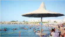  ?? AFP ?? Egyptians enjoy the public beach along the Red Sea resort of Hurghada.