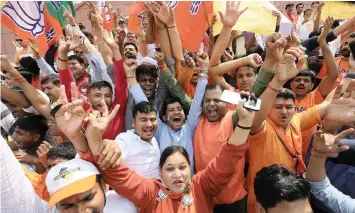  ?? | Reuters ?? SUPPORTERS of Bharatiya Janata Party (BJP) in New Delhi, express happiness over the voting outcome.