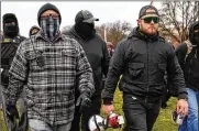  ??  ?? Proud Boys members Joseph Biggs (left) and Ethan Nordean, with megaphone, walk toward the U.S. Capitol on Jan. 6. They face charges from the riot.