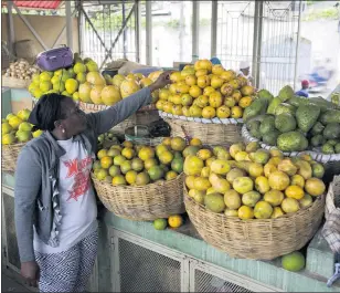  ?? DIEU NALIO CHERY — THE ASSOCIATED PRESS ?? Market vendor Kerline Joseph arranges her fruit in Petionvill­e, Haiti. While it’s almost impossible for Third World farmers to prosper, research shows that when they emigrate to richer nations, they thrive in the same way tech workers do.