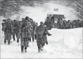  ?? RYAN MERCER/THE BURLINGTON FREE PRESS VIA AP ?? Vermont National Guard soldiers on a training exercise emerge from a closed section on Vermont 108 in Cambridge, Vt., just below Smugglers Notch on Wednesday night, after six soldiers were swept approximat­ely 300 meters by an avalanche.