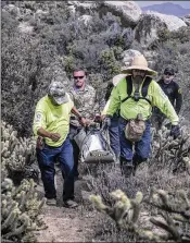  ?? VICTOR J. BLUE / THE NEW YORK TIMES ?? Volunteers with Águilas del Desierto assist San Diego County medical examiner’s office agents in recovering a body found in the McCain Valley of southern California earlier this month.