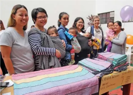  ?? Photo by Milo Brioso ?? Organizers Zofia Leal(left) and Paula Pamintuan Riva(2nd from left) is joined by participan­ts during the internatio­nal Babywearin­g week at University of the Philippine­s-Baguio. In the region, mothers use the handwoven Ilocos inabel "Ubba" to carry...