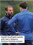  ??  ?? Gareth Southgate speaks with Harry Maguire during a training session.