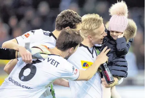  ?? Foto: imago ?? Schlussfei­er im Borussia-Park: Torschütze Oscar Wendt mit seiner Tochter und den Kollegen.