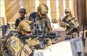  ?? U.S. Embassy in Iraq/AFP via Getty Images ?? American soldiers take positions around the U.S. Embassy in the Iraqi capital of Baghdad on Tuesday.