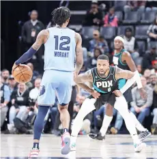  ?? — AFP photo ?? Ja Morant of the Memphis Grizzlies handles the ball against Damian Lillard of the Portland Trail Blazers.