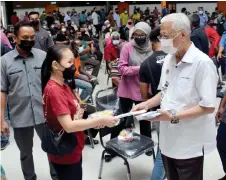  ?? ?? Ismail Sabri hands over BWI aid to a flood victim. — Bernama photo