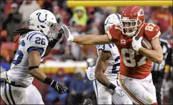  ?? JOHN SLEEZER/KANSAS CITY STAR ?? Chiefs tight end Travis Kelce stiff-arms Indianapol­is Colts safety Clayton Geathers after pulling in a pass Saturday.