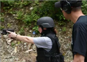  ?? SUBMITTED PHOTO ?? Each participan­t in Basic SWAT School fires with their non-dominant hand, in addition to their dominant hand. Pictured is Ginger Rae Dunbar firing left-handed. An instructor oversees each student.