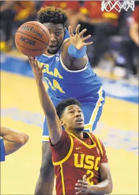  ?? Mark J. Terrill Associated Press ?? USC GUARD Tahj Eaddy drives against UCLA forward Kenneth Nwuba. In addition to hitting the winning shot, Eaddy was one of four Trojans in double figures.