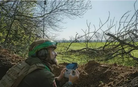  ?? MAURICIO LIMA/THE NEW YORK TIMES ?? A Ukrainian soldier flies a drone last month at a frontline position outside Ivanivske, Ukraine, which is near Bakhmut.