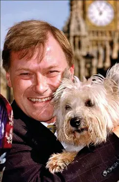  ?? ?? Animal lover: MP, who campaigned against fox hunting, with pet in front of Houses of Parliament