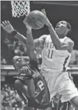  ?? Allen J. Schaben Los Angeles Times ?? MATER DEI’S Xavier Johnson shoots over Long Beach Poly’s Jordan Bell in 1AA title game.