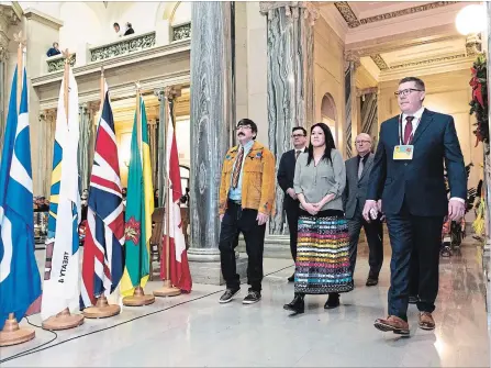  ?? MICHAEL BELL THE CANADIAN PRESS ?? Sixties Scoop Indigenous Society of Saskatchew­an board members Robert Doucette, left, and Melissa Parkyn, front left and centre, Saskatchew­an Party MLAs Paul Merriman and Warren Kaeding, rear left and right, and Premier Scott Moe at the Legislativ­e Building in Regina on Monday.