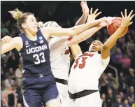  ?? Kathy Willens / Associated Press ?? UConn’s Katie Lou Samuelson (33) knocks the ball from Louisville forward Sam Fuehring, center, and Louisville forward Bionca Dunham (33) during Sunday’s game in Albany, N.Y. Samuelson scored a game-high 29 points.