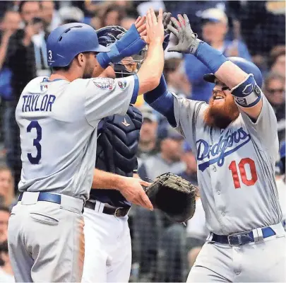  ??  ?? Justin Turner and centerfiel­der Chris Taylor celebrate Turner’s home run.