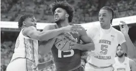  ?? BOB DONNAN USA TODAY Sports ?? Miami forward Norchad Omier (22 points, five rebounds) controls the ball while under pressure from North Carolina forwards Harrison Ingram, left, and Armando Bacot.