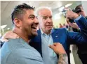  ??  ?? Joe Biden flexes his arm along with Jaime Karnilaw of Concord, N.H., during a stop at Gilford Community Church in Gilford, N.H.