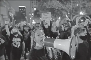  ?? Ap-john Minchillo ?? Protesters march Thursday in Louisville, Ky. Authoritie­s pleaded for calm while activists vowed to fight on in Kentucky’s largest city, where a gunman wounded two officers during protests following the decision not to charge officers for killing Breonna Taylor.