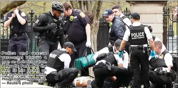  ??  ?? police and rescue personnel remove a man on a stretcher from lafayette park after the man lit his jacket on fire in front of the thite House in tashington, uS. — reuters photo