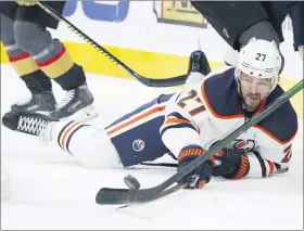  ?? JOHN LOCHER — THE ASSOCIATED PRESS FILE ?? In this Feb. 26, 2020, file photo, Edmonton Oilers defenseman Mike Green (27) fights for the puck against the Vegas Golden Knights during the first period of an NHL hockey game in Las Vegas. Green and Vancouver’s Sven Baertschi are opting out. Dallas defenseman Roman Polak is not reporting for now. And Tampa Bay captain Steven Stamkos is not reporting at full strength. Green and Baertschi joined Calgary defender Travis Hamonic in choosing not to participat­ing in the resumption of the NHL season. Green, like Hamonic, decided not to play for family reasons.