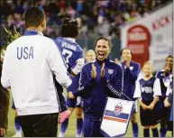  ?? Elaine Thompson / Associated Press ?? The United States’ Shannon Boxx, right, is greeted by her husband Aaron Spearman and their daughter Zoe Spearman, 20 months, before a 2015 friendly in Seattle. The match was Boxx’s last of her career. Boxx has been voted into the National Soccer Hall of Fame and will be enshrined on May 21 in Frisco, Texas.