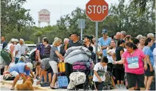  ?? AFP-Yonhap ?? People wait in line to enter the Germain Arena which is serving as a shelter from the approachin­g Hurricane Irma in Estero, Fla., Sunday. Irma made landfall hours earlier in Cuba with maximum-strength Category 5 winds.