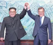  ?? KOREA SUMMIT PRESS POOL VIA AP ?? North Korean leader Kim Jong Un (left) and South Korean President Moon Jae-in raise their hands after signing a joint statement Friday at the border village of Panmunjom in the Korean Peninsula’s Demilitari­zed Zone.