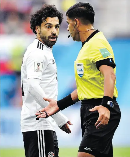  ?? MARTIN MEISSNER / THE ASSOCIATED PRESS ?? Egypt’s Mohamed Salah, left, and referee Enrique Caceres talk during the Group A match Tuesday between Russia and Egypt at the 2018 World Cup in St. Petersburg.