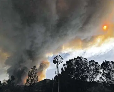  ?? Al Seib Los Angeles Times ?? SMOKE blocks out the sun as f lames consume dry brush near Soledad Canyon Road in the mountains near Acton. A fire agency spokesman said the Sand fire was scorching an average of 10,000 football fields a day.