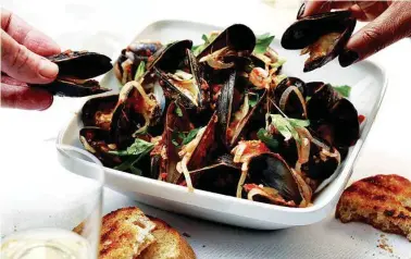  ?? E. JASON WAMBSGANS/CHICAGO TRIBUNE/TRIBUNE NEWS SERVICE ?? Mussels can be cooked myriad ways; this version keeps it simple with tomatoes, white wine, garlic and red pepper flakes.