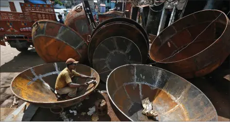  ?? REUTERS ?? A worker uses a grinder on the joints of a giant utensil at an iron utensils manufactur­ing unit in Kolkata, on Wednesday.