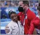  ?? GREGORY BULL — THE ASSOCIATED PRESS ?? Coach Laurent Landi embraces Simone Biles, after she exited the team final with apparent injury, at the 2020 Summer Olympics, Tuesday, July 27, 2021, in Tokyo. The 24-year-old reigning Olympic gymnastics champion Biles huddled with a trainer after landing her vault. She then exited the competitio­n floor with the team doctor.