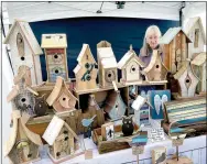  ?? File photo ?? Sharon Sherman of Birdwerks Home Decor looks out from behind some of the birdhouses and decor items that she and her husband, Dan Sherman, create from recycled lumber during the Fall Craft Show at Wishing Spring. Some of the bird houses contain wood and fixtures salvaged after the Joplin tornado.