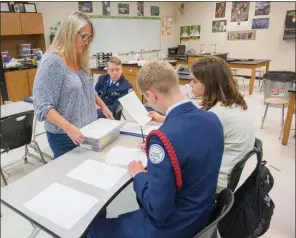  ?? MARK BUFFALO/THREE RIVERS EDITION ?? Cabot High School Advanced Placement biology teacher SueAnn Whisker, clockwise from left, goes over work with students Austin Badger, Ethan Hunt and Christian Pittman.