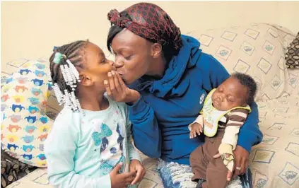  ?? LLOYD FOX/BALTIMORE SUN ?? Vanessa Sims holds Chance as she kisses her daughter Da’Neia Johnson. Sims’ other daughter is named Paige.