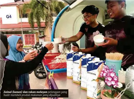  ??  ?? Zainal (kanan) dan rakan melayan pelanggan yang hadir membeli produk makanan yang dijualnya