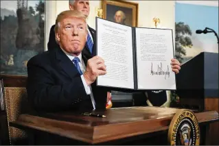  ?? CHIP SOMODEVILL­A / GETTY IMAGES ?? President Donald Trump holds up a proclamati­on Wednesday at the White House declaring that the U.S. government will formally recognize Jerusalem as the capital of Israel. Trump also said the United States will move its embassy from Tel Aviv to...