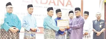  ??  ?? Aidi (third left) presenting a certificat­e to agencies that were involved in the Hari Raya celebratio­n.