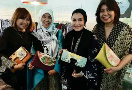  ?? PIC BY ZAHARAH OTHMAN ?? Hajah Rosmaniar with her daughters, wearing clothes from Qarya collection and holding clutches from House of Chinta.