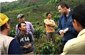  ?? AFP photo ?? File photo shows Falch (right) conferring with local officials at a coffee plantation in Houaphan province. —