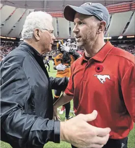 ?? DARRYL DYCK THE CANADIAN PRESS ?? B.C. Lions head coach Wally Buono, left, and Calgary Stampeders head coach Dave Dickenson meet at centre field after Buono coached his last regular-season Canadian Football League game in Vancouver on Saturday. Calgary won, 26-9.