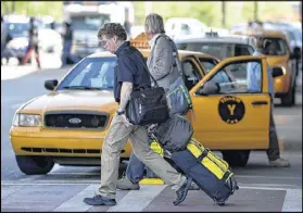  ?? BRANT SANDERLIN/BSANDERLIN@AJC.COM ?? These passengers were walking to an airport shuttle at Hartsfield Jackson Internatio­nal Airport, but some passengers are bypassing traditiona­l transporta­tion, instead opting for social media-based ride services such as Uber.